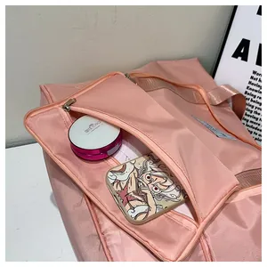 Pink nylon travel bag detail showing the front zipper pocket with cosmetics for storage