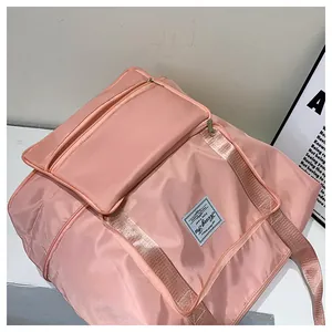 Detail view of the pink travel bag featuring a reinforced zipper and front zipper pocket
