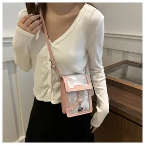 Pink printed crossbody phone bag shown on a model in a warm indoor setting