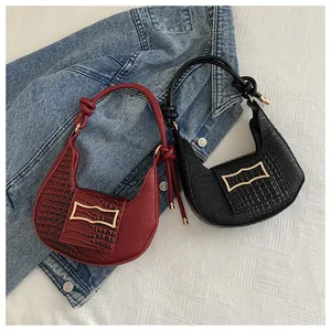 Detailed close-up of hobo bag featuring crocodile pattern leather and metallic buckle
