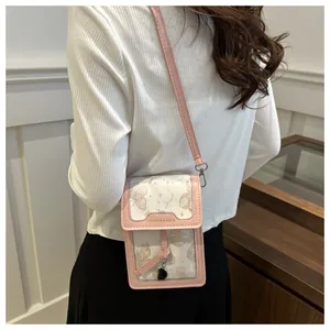 Detail of pink and white crossbody phone bag with butterfly print and embossed logo