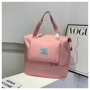 Macro view of the pink travel bag featuring front zip pockets and the brand woven label