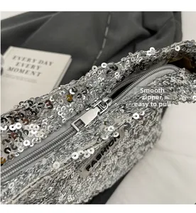 Detailed macro view of the smooth silver zipper on a sequin-covered fashion tote bag