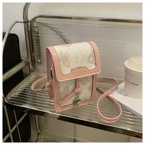 Detailed shot of pink and beige crossbody phone bag with floral pattern on metal shelf