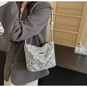 Detail of silver sequin shoulder bag with knot strap and black Fashion label