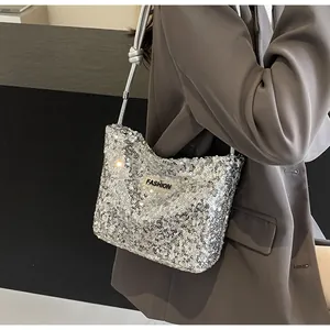 Close-up of sparkling silver sequin shoulder bag with knot detail and FASHION label