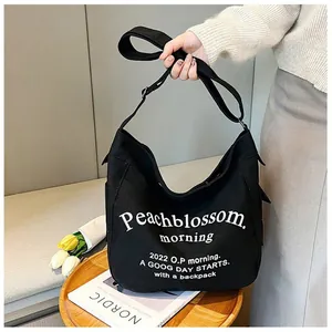 Sac cabas en toile noire avec lettrage blanc et bandoulière réglable de style décontracté
