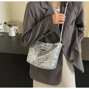 Detail view of silver sequin crossbody bag with FASHION tag on grey blazer outfit