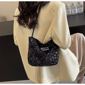 Close-up of a black sequined tote bag with FASHION label on a model shoulder