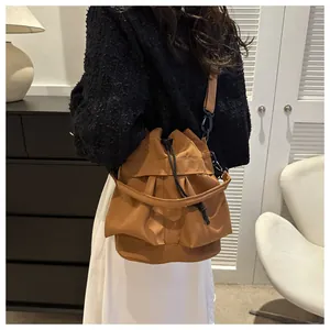Detail van de bruine bucket bag met trekkoord, gelaagde ruches en verstelbare riem