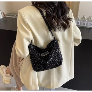 Detailed view of black sequined tote bag with Fashion label on stylish model