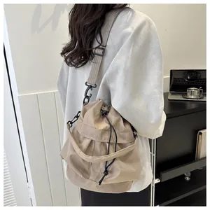 Kaki bucket bag met verstelbare brede schouderriem en detail van het handvat bovenop
