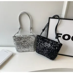 Detail of sequin tote bag with FASHION metal logo and stylish leather shoulder straps