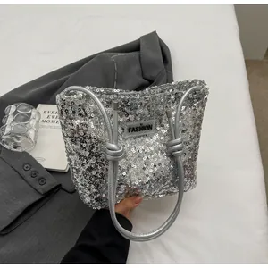 Detailed shot of silver sequin tote bag featuring rope knot handle and Fashion label