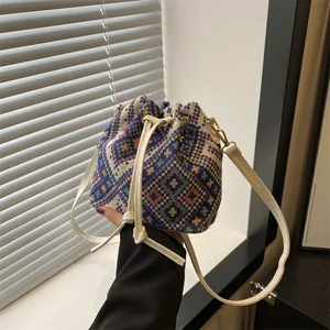 Ethnic style bucket bag with colorful geometric patterns and cream drawstring straps