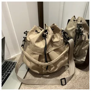 Détail du sac seau en nylon kaki avec fermeture à cordon et poches extérieures multiples
