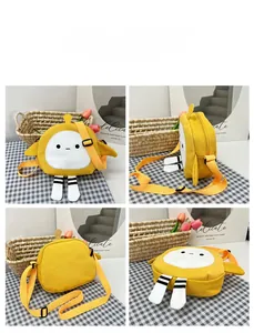 Detail view of a yellow cartoon crossbody canvas bag with cute feet and wing features