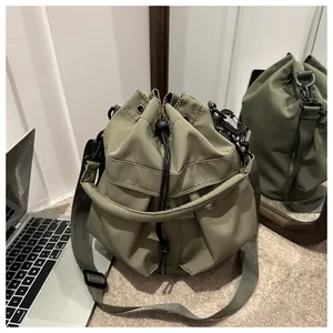 Détail du sac seau en nylon vert armée avec fermeture à cordon et mousqueton en métal