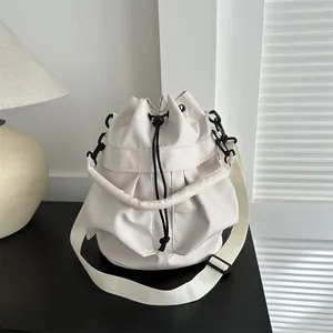 Sac seau minimaliste blanc crème à cordon avec bandoulière large et détails noirs