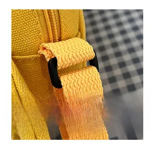 Detail of durable black D-ring strap connector and yellow canvas weave on cute bag