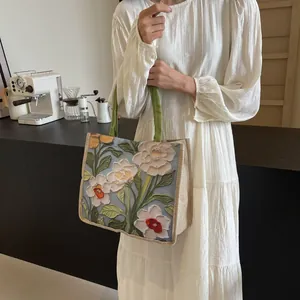 Détail du sac cabas artistique avec motif floral 3D et bandoulières vertes