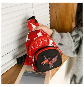 Détail du sac banane rouge pour enfants avec motifs dinosaures et écusson ptérosaure 3D