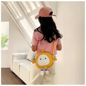 Detail showing back view of yellow cartoon canvas crossbody bag worn by a child
