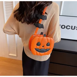 Detail view of pumpkin crossbody bag with bat wing decorations on a shoulder strap