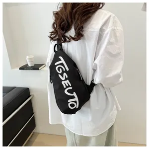 Détail d'un sac bandoulière noir avec texte TGSEUTO blanc porté par un mannequin