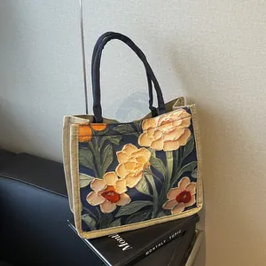 Vue détaillée de la texture du sac cabas en toile à fleurs et des anses tressées