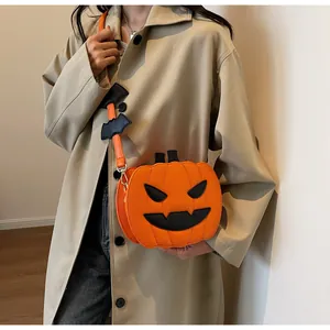 Detail of Halloween pumpkin shoulder bag featuring a black bat charm and Jack-o'-lantern face