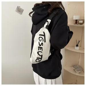 Vista dettagliata del marsupio in tela bianca con scritte graffiti su outfit casual