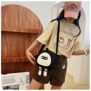 Detail of cute black cartoon egg-shaped canvas crossbody bag with funny hanging legs