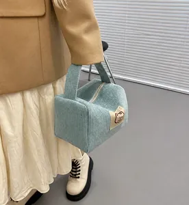 Dettaglio della borsa cosmetica in velluto a coste azzurro con toppa a forma di gatto
