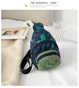 Détails de broderie dinosaure et motifs sur une sacoche banane enfant bleu marine