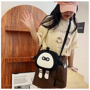 Detail of creative cartoon monster crossbody canvas bag worn by model in a stylish setting