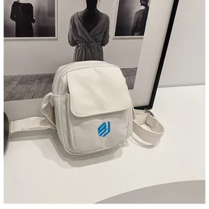 Close-up of a white outdoor mini crossbody bag featuring a blue embroidered geometric logo