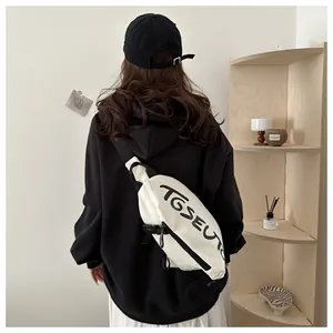 Détail du sac de poitrine blanc TGSEUT avec sangle en nylon noir et imprimé artistique
