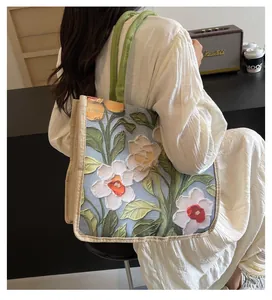 Détail du sac cabas jacquard à fleurs avec anses vertes et coutures en toile de jute