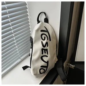 Détail du sac bandoulière en toile blanche avec imprimé TGSEUTO et sangle en nylon noir