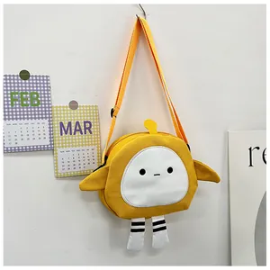 Detail of yellow canvas cartoon crossbody bag with decorative wings and leg charms