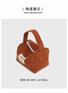 Vista laterale di una borsa cosmetica in velluto a coste con toppa di orsetto