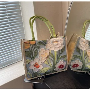 Détail du sac cabas rétro à motif floral avec texture en jute et anses en tissu vert