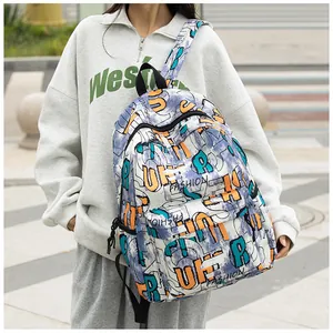 Foto callejera de mochila con estampado de grafiti y letras de moda llevada por modelo