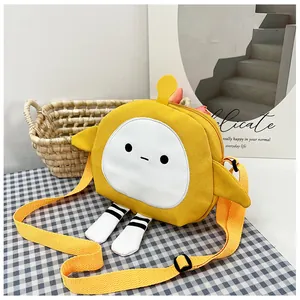 Detail of yellow canvas crossbody bag featuring cute cartoon legs and adjustable strap