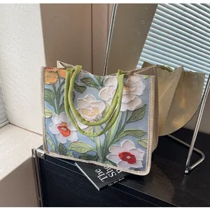Détail de broderie florale sur cabas en jute avec textures de fleurs en relief 3D