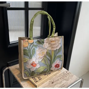 Vue détaillée du motif floral en relief 3D sur ce grand sac cabas en lin chic