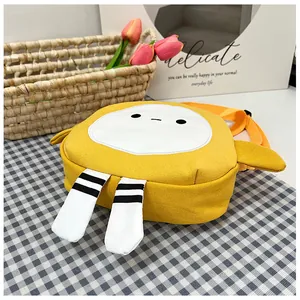 Detail of yellow cartoon canvas crossbody bag with striped legs and orange strap