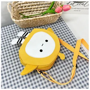 Close-up of yellow cartoon canvas crossbody bag with adjustable strap and floral decor