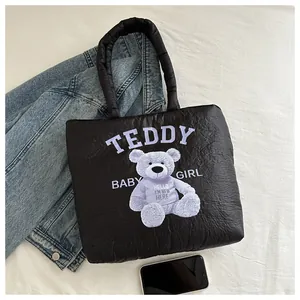 Detail of black quilted canvas bag with purple teddy bear print and comfortable handles